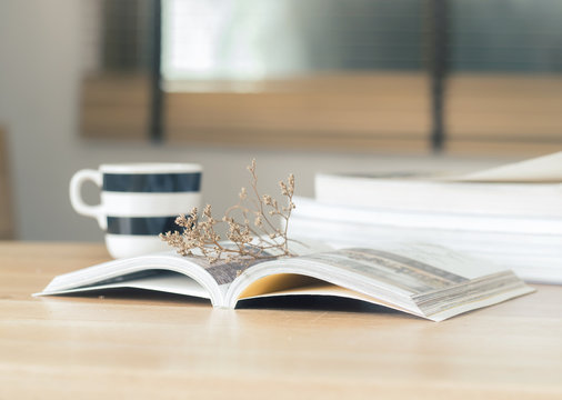 Open book with dried flower on the desk ( selective focus  )