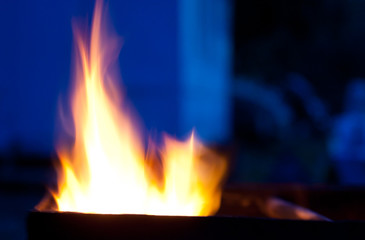 Blurred silhouettes of flames of fire in the evening (as an abstract background), with copy space on the right for your text