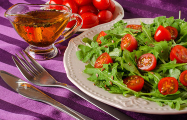Salad of arugula and tomatoes with oil and herbs.