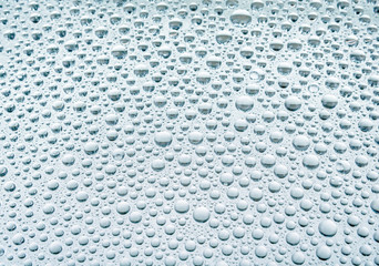 Blue drops of water on glass repellent
