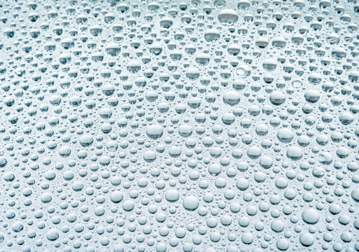 Blue drops of water on glass repellent