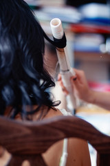 Fototapeta premium hairdresser uses curling hair