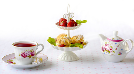 Cream puff cakes or profiterole filled with whipped cream served with strawberries in plateau