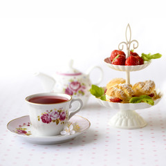 Cream puff cakes or profiterole filled with whipped cream served with strawberries in plateau