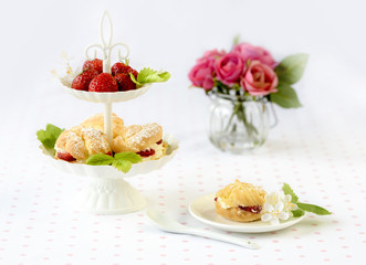 Homemade cream puffs or profiterole filled with whipped cream served with strawberries in plateau