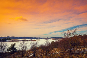 River bank in snowy winter at sunset