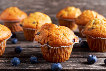 Homemade Blueberry Muffins with fresh berries on wooden table.