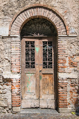 Old wooden door with brick archway.