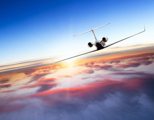 Private jet plane flying above clouds