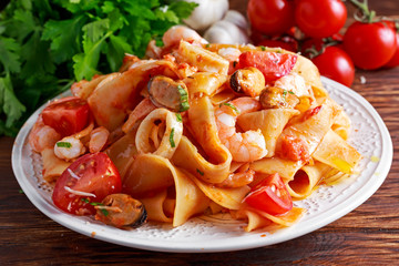 Tasty Pappardelle pasta with shrimp, Squid, mussel, tomatoes and herbs.