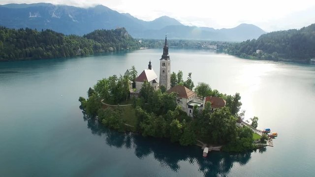 AERIAL VIEW: flight over Lake Bled in Slovenia .View of the Church of the Assumption of the Virgin Mary