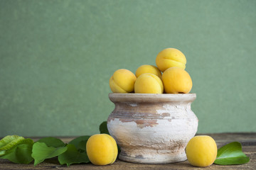 fresh apricot and jam canned apricots, berries and ornamental bucket, fresh Organic Apricots in pottery with leaves, space for text conservation recipes. selective focus 