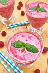 Raspberry smoothies with fresh berries on a wooden table