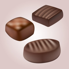 various chocolate pralines on pink background