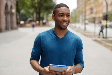 Young black man in city using tablet computer