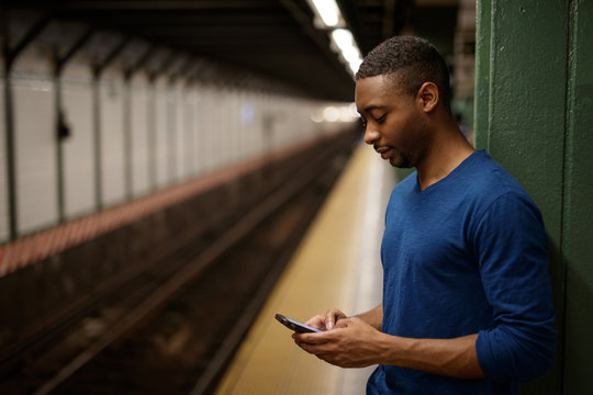 Young man in city texting cell phone