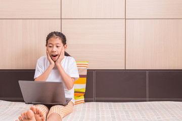 Happy asian girl using computer laptop notebook with surprise ex