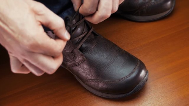 Man laces his shoes. Closeup. Shallow depth of field. 