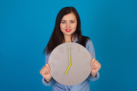 Round, grey clock and woman