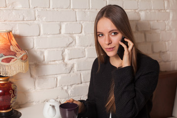 Woman with tea and smartphone