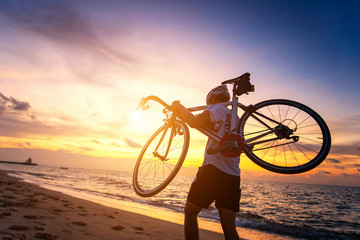 Fototapeta premium Hiker with bicycle watching sunset