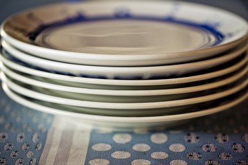 Tisch gedeckt mit Stapel von Tellern und Essbesteck