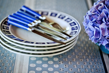 Tisch gedeckt mit Stapel von Tellern und Essbesteck
