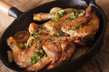 Chicken tobacco with herbs and garlic in a pan close-up. horizontal
