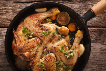 Chicken tobacco close-up in a frying pan on the table. horizontal top view 
