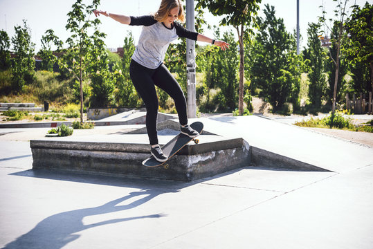 Skateboarding woman practicing at skatepark