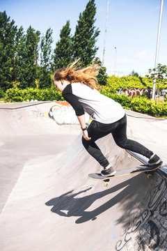 Skateboarding woman practicing at skatepark