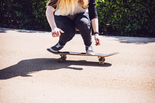 Skateboarder woman practicing ollie at park