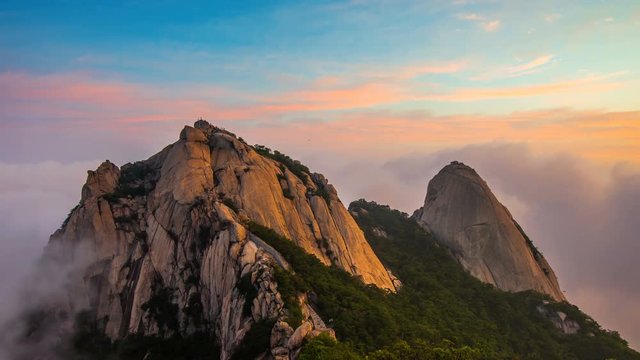 Time lapse of Bukhansan mountains is covered by morning fog and sunrise in Seoul,Korea.