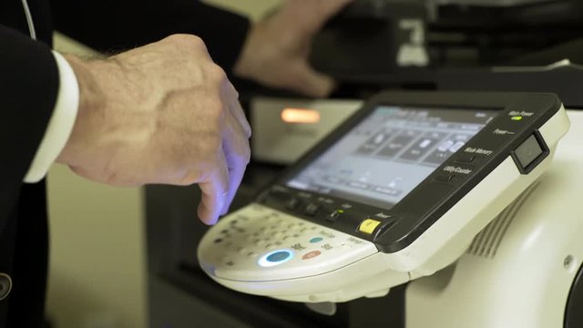 businessman at a large copier making copies 4k
