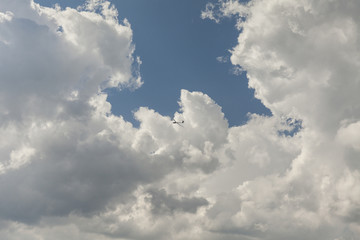 Naklejka na ściany i meble RC glider aeromodelling flying in the blue sky, white clouds background