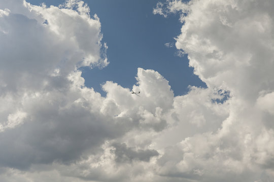 RC glider aeromodelling flying in the blue sky, white clouds background