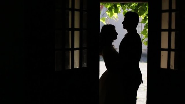 Young Couple in Silhouette in front of Door