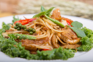 Spaghetti pasta with tomatoes and parsley on wooden table.  