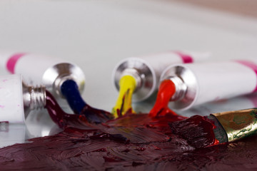 Open tubes of paint mixing with brush