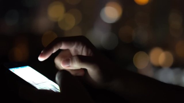 Man Browsing Social Net Using Mobile Phone at Evening Time at Roof in Big City. Close-Up. 4k