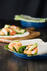 Crumbed fish fillet burrito with avocado and tomato