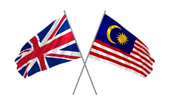 UK and Malaysia flags crossed and waving in the wind