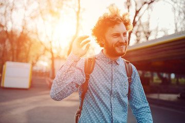 Outdoor lifestyle portrait of handsome ginger guy with backpack