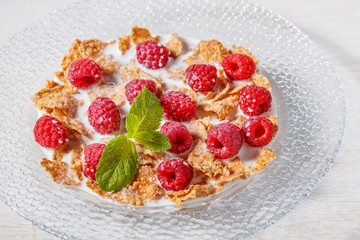 Wheat flakes with raspberries and milk.