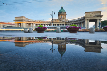 Russia, Saint-Petersburg, 03 July 2016: Reflection of Kazan Cathedral in a pool on the sidewalk of the Nevsky of the prospectus, after a rain, tourists, sunset, water mirror, long exposure lights