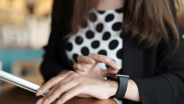 Woman with smart watch working on tablet