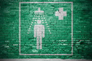 Rettungszeichen Notdusche Ziegelsteinmauer Graffiti