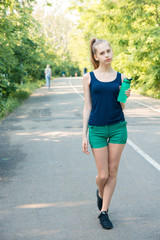 Thirsty fitness girl holding bottle of water