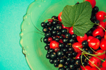 Black currant and cherries on blue background