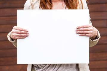 woman outside with a blank white card
